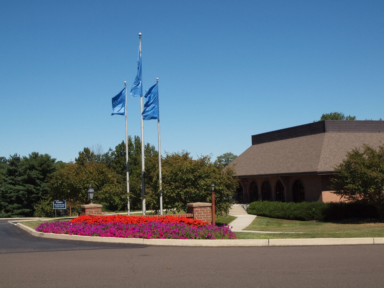 Exterior of clubhouse, showing flowerbed and flags
